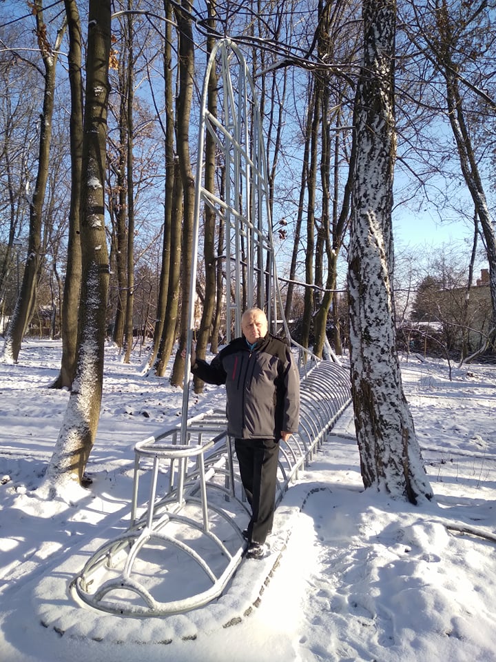 mężczyzna stoi w lesie przy metalowej konstrukcji