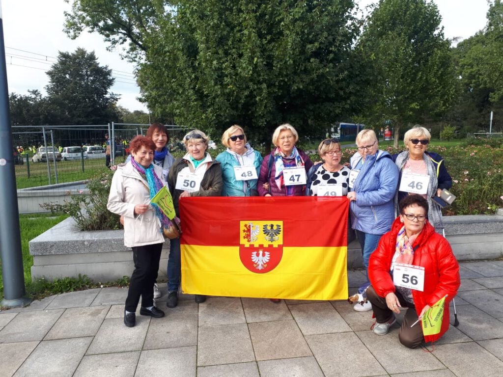 VI Międzynarodowe Senioralia w Krakowie, seniorzy trzymają flagę 