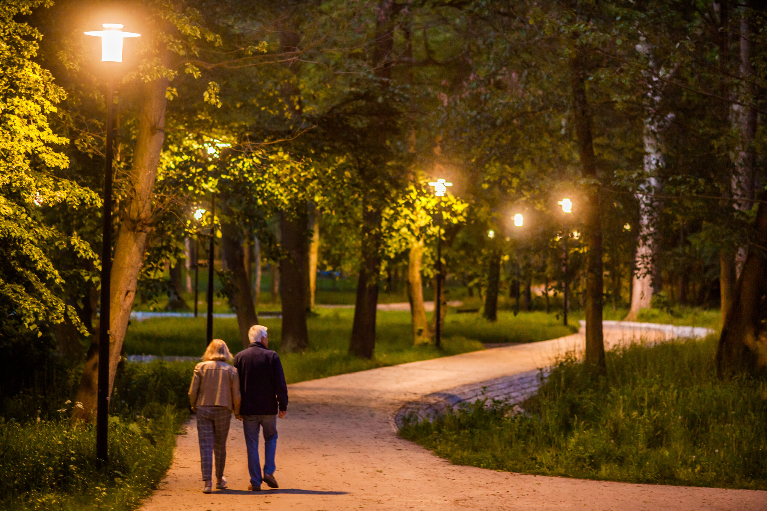 para seniorów wieczorem spacerują w parku