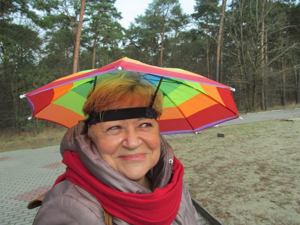 kobieta z kapeluszem zrobionym z kolorowego parasola