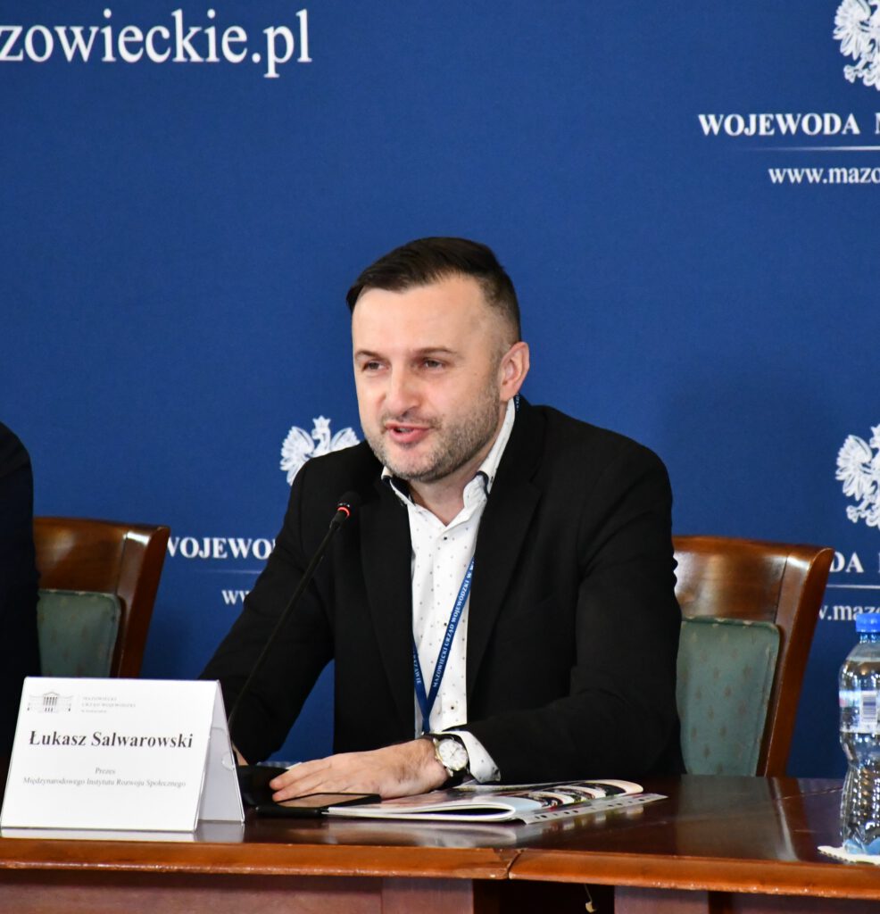 konferencja "bezpieczny i aktywny senior", Łukasz Salwarowski mówi do mikrofonu