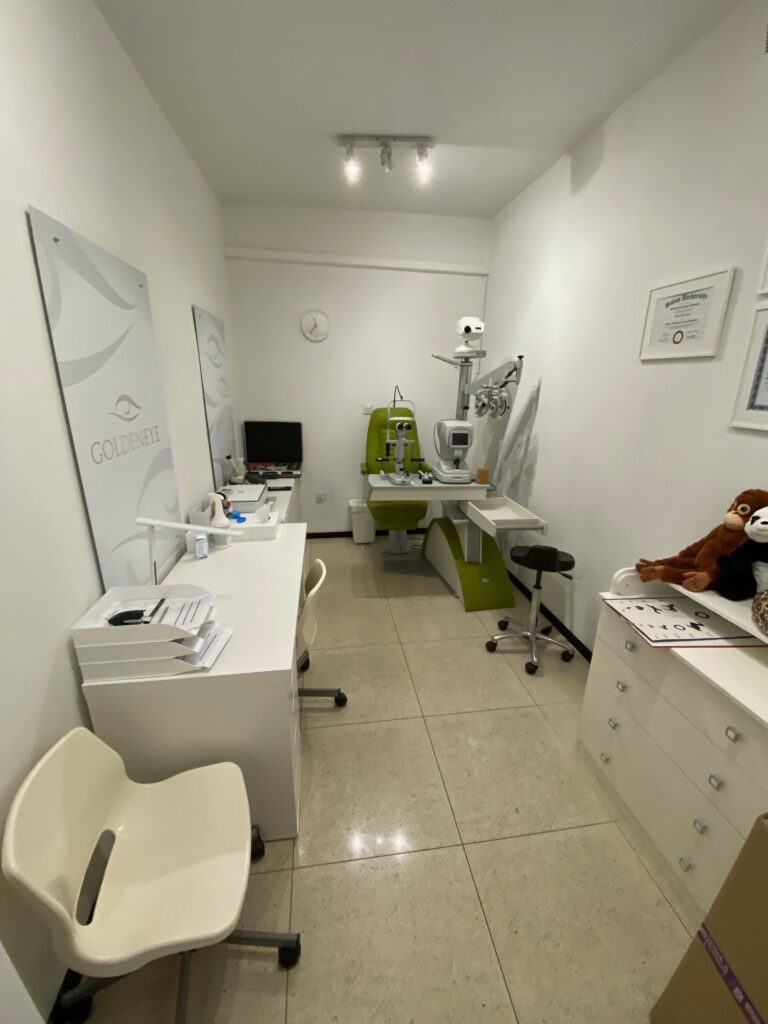 wnętrze salonu okulistycznego, sprzęt specjalistyczny do badania wzroku,  jasne meble
